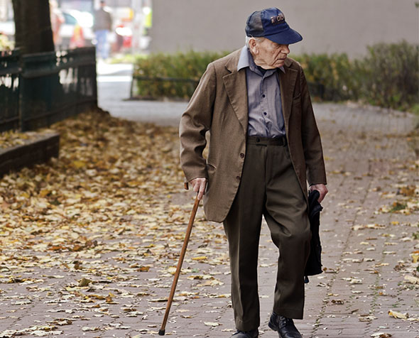 Elderly man walking on pavement