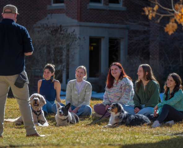 man teaching students with dogs