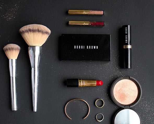 two makeup brushes, lip liner, lipstick, mirror and earrings