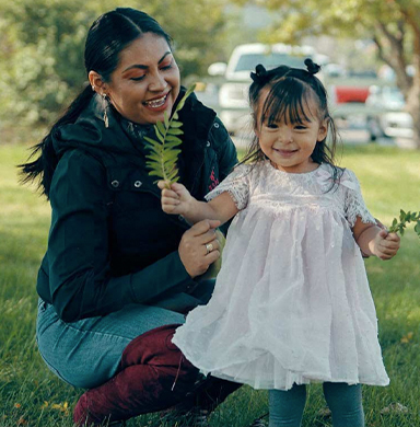 A child and an adult playing with a branch