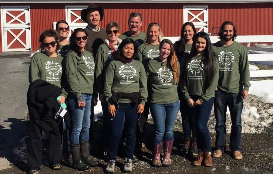 group of students posing in front of a barn