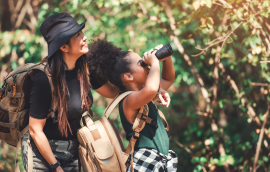 woman with child looking at nature with binoculars