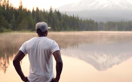Person staring at a mountain lake