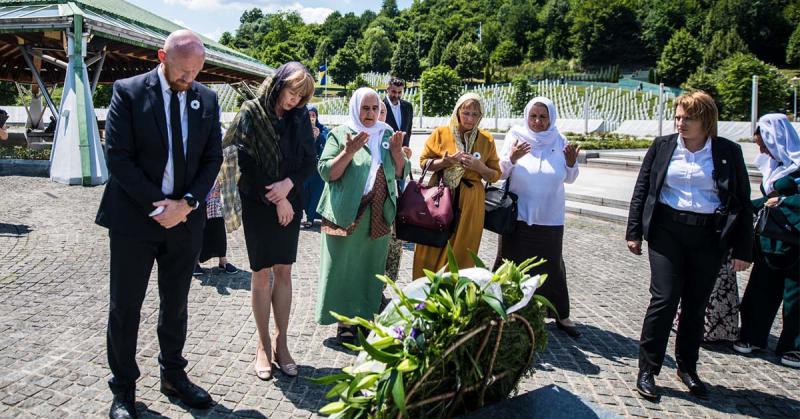 group of people standing at a memorial