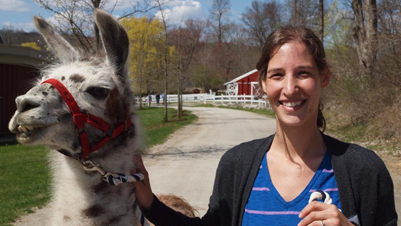 woman smiling next to alpaca