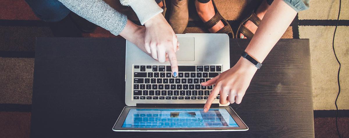 two sets of hands typing 