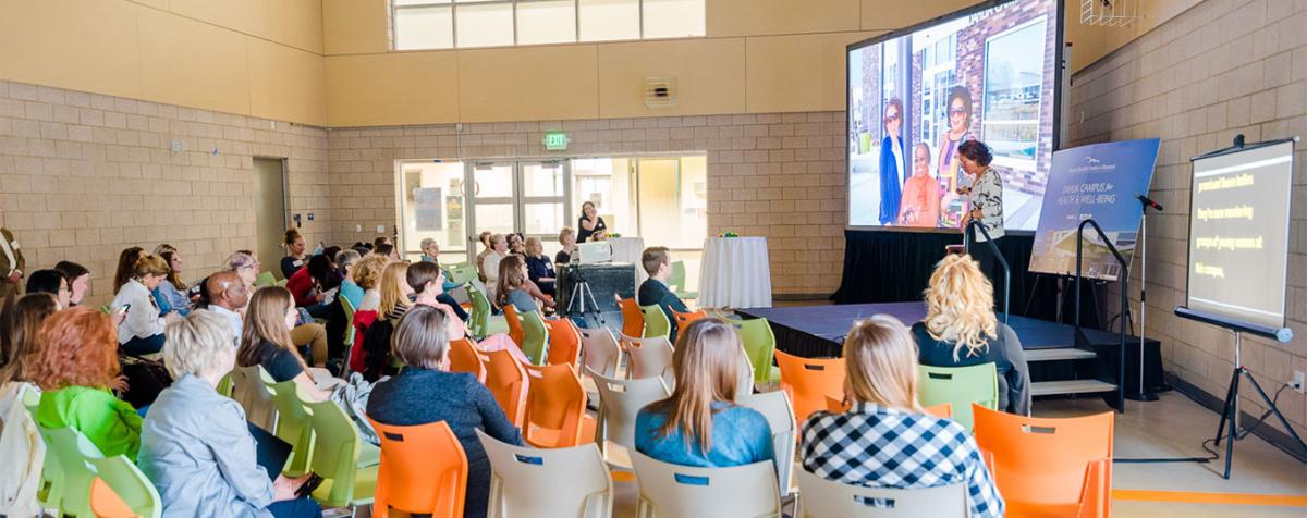 Woman on stage presenting to an audience