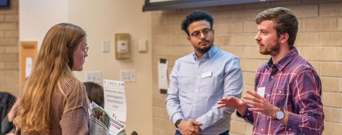 Student at job fair speaking with a man at a table