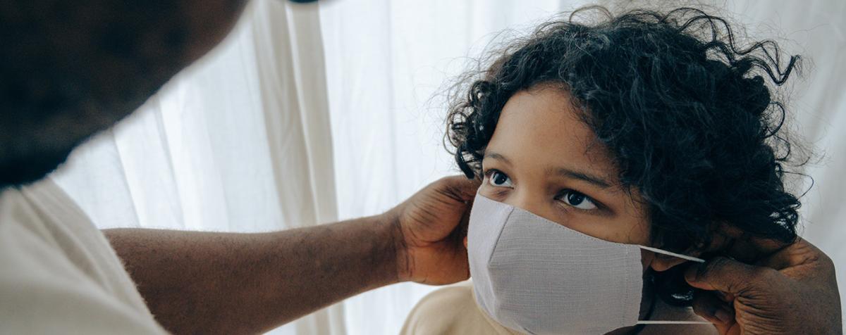 A young child wearing a facial mask 