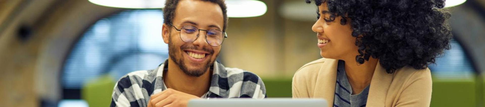 two people at a computer smiling