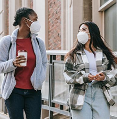 Two girls walking with masks on