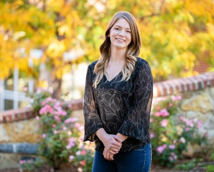 Ashley Taeckens-Seabaugh standing outside on campus at DU